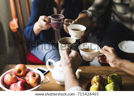 Hands holding tea cups clinking together
