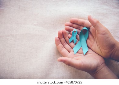 Hands Holding Teal Ribbons, Copy Space Toning Background, Ovarian Cancer, Cervical Cancer, Sexual Assault , Pcos Awareness