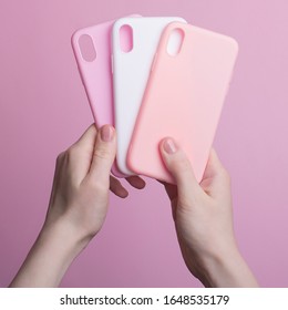 Hands Holding Three Colorful Smartphone Cases Isolated On Pink Background, IPhone X Phone Cases