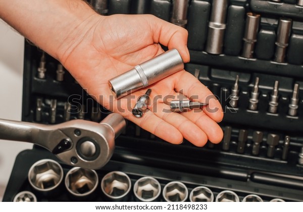 Hands holding tools wrench and nuts on the
background of a box for a
motorist.