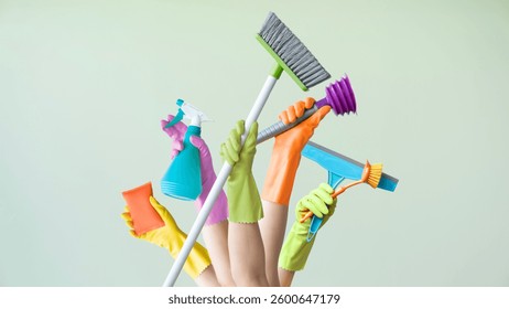 Hands holding various cleaning objects