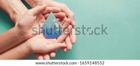 Hands holding water drop,world water day,clean water and sanitation, hand sanitizer and hygiene for covid pandemic, vaccine,family washing hands, CSR, save water, clean renewable energy concept 