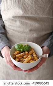  hands holding white bowl with pasta, food cooking