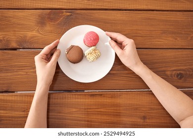 Hands holding white plate with assorted macarons on rustic wooden table background. - Powered by Shutterstock