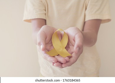 Hands Holding Yellow Gold Ribbon, Sarcoma Awareness, Bone Cancer, Childhood Cancer Awareness, September Yellow, World Suicide Prevention Day Concept
