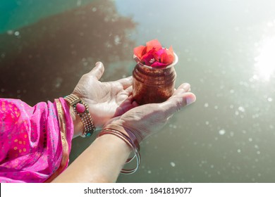 Hands of an Indian woman, pouring sacred water into the water of the Ganges. Doing a ritual (puja) in the river. - Shutterstock ID 1841819077