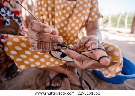 hands of indigenous woman weaving backpack, guajira colombia