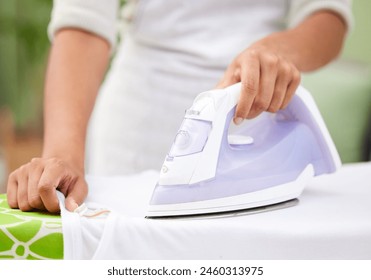 Hands, iron and laundry for closeup in home with tools, working and cleaning service for wrinkles in fabric. Person, cleaner and machine for clothes with housekeeping, board and press at apartment