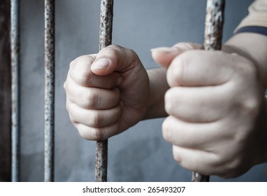 hands of jail holding prison bars - Powered by Shutterstock