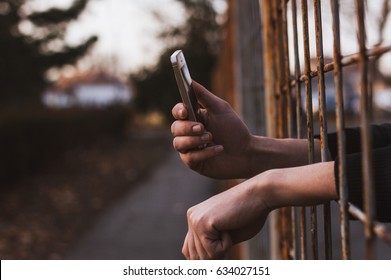 Hands In Jail Using Phone.