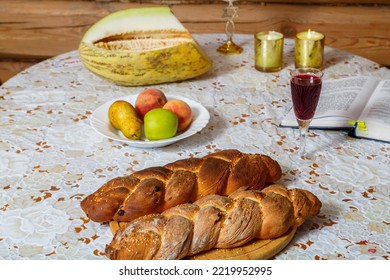The Hands Of A Jewish Woman Break The Challah For The Traditional Shabbat Blessing On The Festive Table. Horizontal Photo