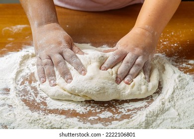 The Hands Of A Jewish Woman Knead The Dough For Challah For A Festive Meal On Shabbat On A Wooden Table. Horizontal Photo