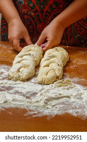 The Hands Of A Jewish Woman Weave Challah With A Pigtail For Shabbat. Vertical Photo