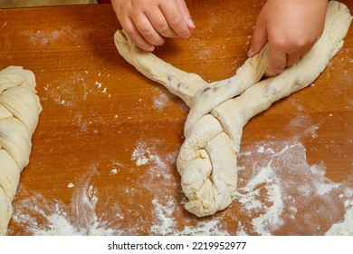 The Hands Of A Jewish Woman Weave Challah With A Pigtail For Shabbat On A Wooden Table In Flour. Horizontal Photo