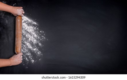 hands keep rolling pin with flour on dark black table - Shutterstock ID 1615294309