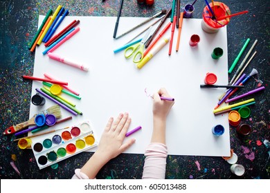 Hands of a kid drawing with highlighters on paper - Shutterstock ID 605013488