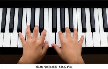 Hands Of Kid On Piano Keyboard