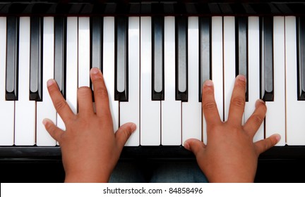 Hands Of Kid On Piano Keyboard