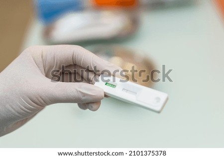 Hands of laboratory assistant in gloves analyzing blood sample. COVID-19 and coronavirus identification. Pandemic concept