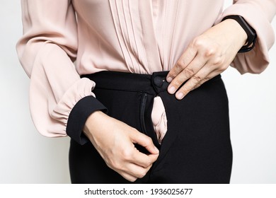 Hands of lady girl trying to zipping up her pants,try to close her tight pants with difficult from fat,weight gain,overweight or asian business woman having problem with zipper of trousers,bad quality
