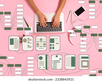 Hands with laptop and different website wireframes on pink background