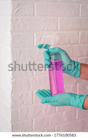 hands in latex gloves holding antiseptic bottle. Antiseptic bottle, safety, covid, cleanliness concept