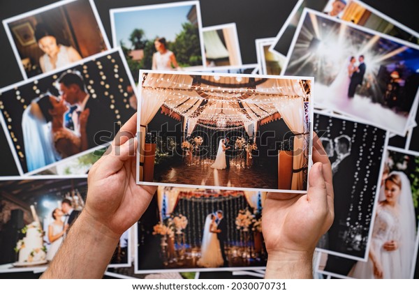hands lay out a printed\
copy of the wedding photos. the result of the photographer\'s work\
at the wedding. printed products. a photo session of the bride and\
groom.