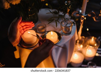 Hands light a candle. Decoration, arrangement and location preparation for surprise marriage proposal. Romantic candlelight dinner at terrace restaurant at night. Place for date or engagement in park.