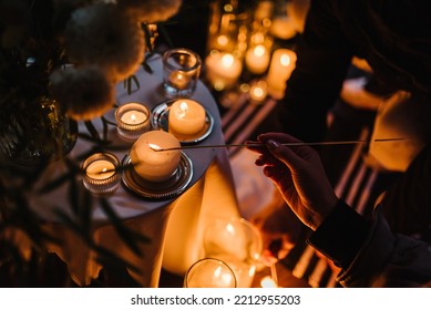 Hands Light A Candle. Decoration, Arrangement And Location Preparation For Surprise Marriage Proposal. Romantic Candlelight Dinner At Terrace Restaurant At Night. Place For Date Or Engagement In Park.