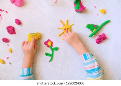 Hands of little girl making flower and sun and other  from colorful clay dough, plasticine, Home Education game with clay. Early development concept - Powered by Shutterstock