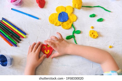 Hands of little girl making flower and sun and other  from colorful clay dough, plasticine, Home Education game with clay. Early development concept. Educational and entertaining classes with children - Powered by Shutterstock