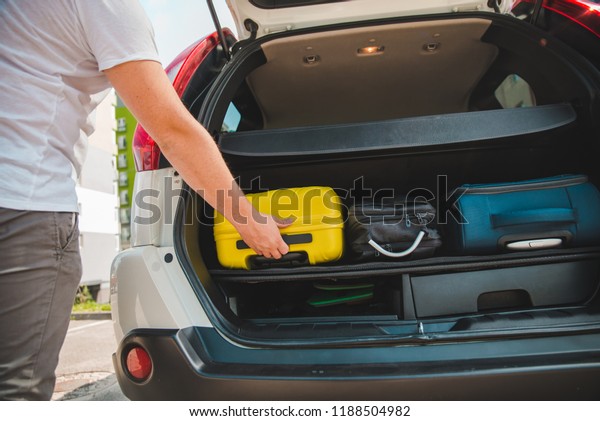 hands load\
bags in car trunk. car travel\
concept