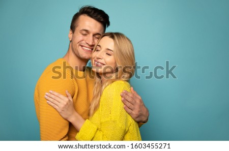 Hands of the loved one. Close-up photo of a blonde girl and a happy man, who are hugging each other tightly and smiling with their eyes closed.