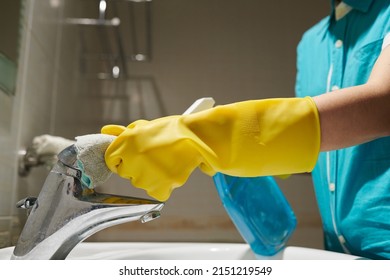 Hands Of Maid Wearing Silicone Gloves When Cleaning Water Tap In Bathroom