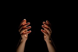 Hands Make Magic, Or Pray That The Light Falls From Above On Hand. Radiance Between The Palms. Gestures, Black Background