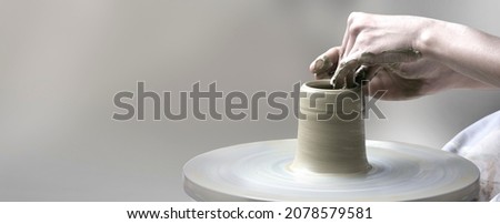 hands making ceramic cup on potter's wheel
