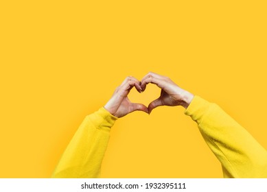 Hands Making Heart Shape Isolated On A Yellow Background - Love And Minimal Fashion Concept