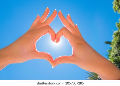 Hands Making a Heart with Sunny Sky Blue Sackground