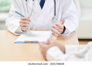 Hands Of A Male Doctor Explaining Symptoms To The Patient