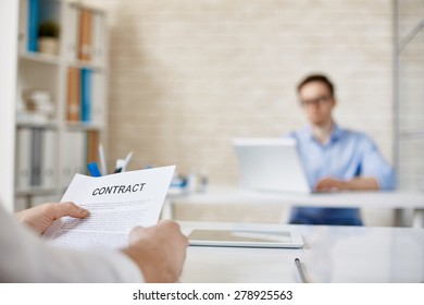 Hands Of Male Employee With Contract Over Workplace In Working Environment