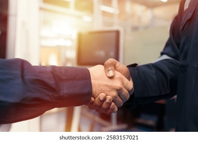 Hands of male engineer handshake together in workshop room of building. Successful, Unity and teamwork, Finished and completed work concept