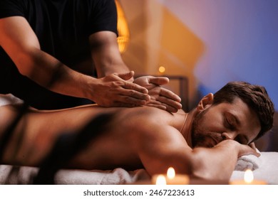 The hands of the male masseur are actively rubbing the visitors back, a therapeutic massage for tired muscles. Point massage in the spa center. Body therapy for a healthy lifestyle. - Powered by Shutterstock