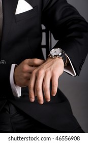 Hands Of The Man In A Black Suit And Expensive Watch