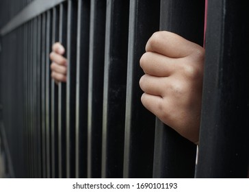 Hands of man catch in the iron prison. Man in prison, hope to be free. Crime - Prison Cell Bars.