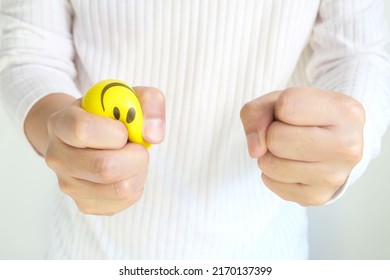 Hands of man with a gentle personality He exhibits stressful behavior from work, and he squeezes the yellow ball expressing emotion, anger, displeasure. Medical concepts and emotional regulation - Shutterstock ID 2170137399