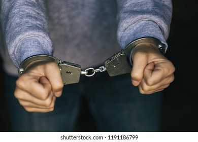 Hands of man in handcuffs, close-up - Shutterstock ID 1191186799