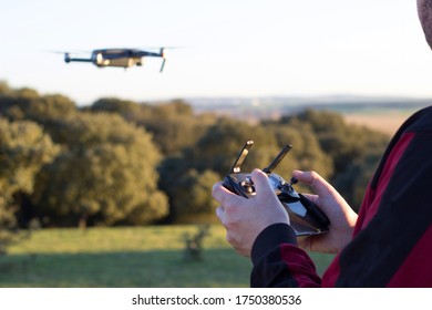 Hands Of A Man Holding A Joystick To Fly A Drone In The Field