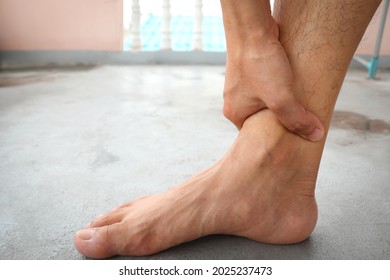 Hands Of A Man Holding Onto His Ankle, Suffering From Nerve Endings Beriberi In Guillain Barre Syndrome, A Possible Side Effect Of The COVID-19 Vaccine.