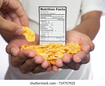 Hands of a man holding a pile of cereals with nutrition facts placing in. Another hand picking a cereal from the pile.