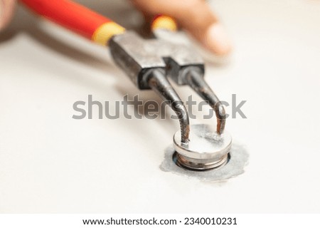 Hands of man holding pliers,turn the pliers counterclockwise(to the left)to loosen the nut,unscrew the lid cover from the tiled floor,before termite control service or injecting termiticides into soil